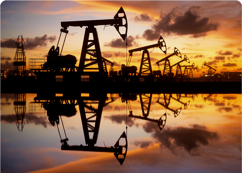 Oil pumps silhouetted against sunset sky.